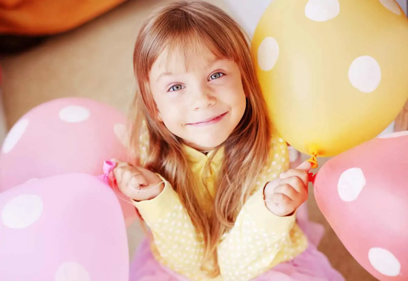 A bedroom doorway filled with balloons as a birthday morning surprise for a child.