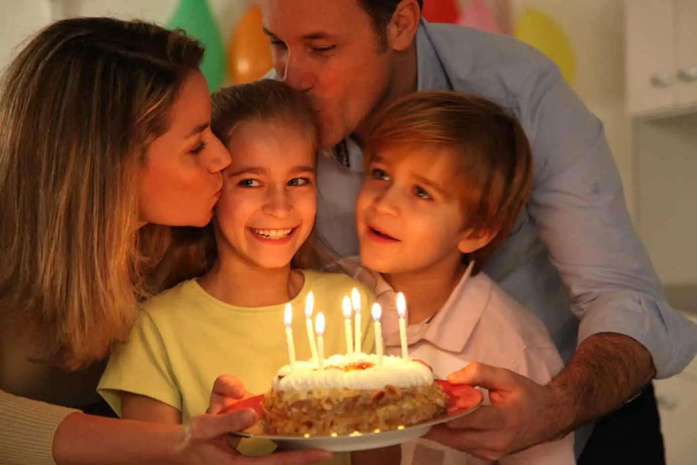 A family celebrating a child's birthday at home — 20 ways to make a birthday special without a big party or going over budget.